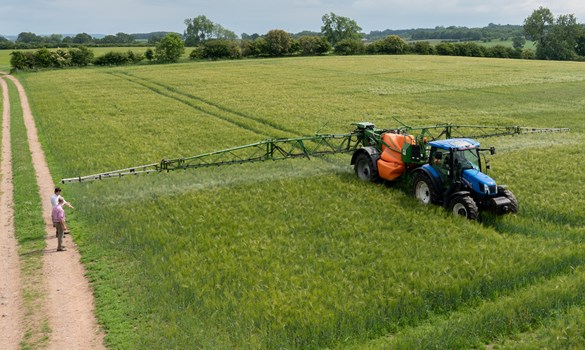 a person walking next to a tractor on a dirt road